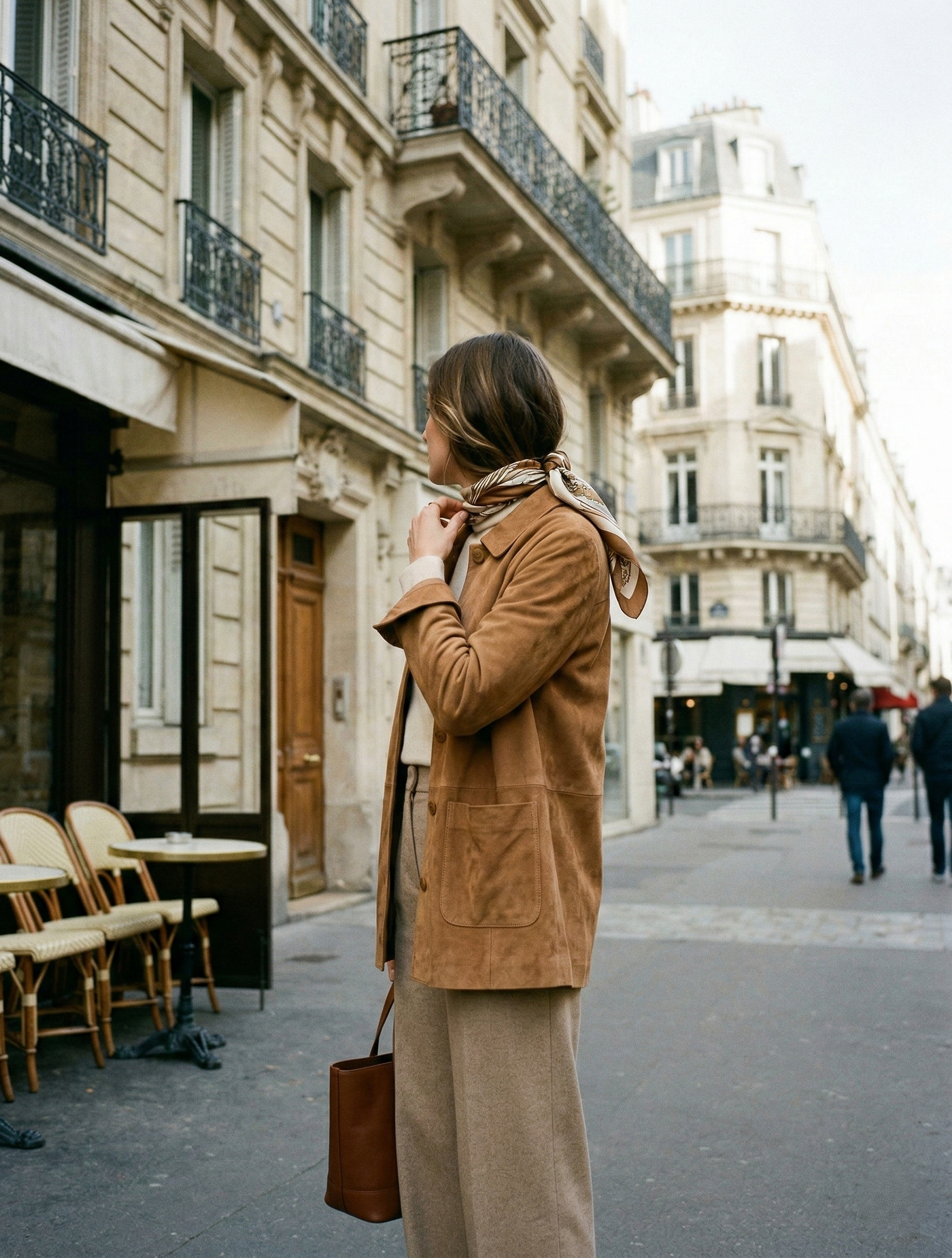 Woman in Paris wearing a Sézane camel suede Will jacket with a silk scarf and wide-leg trousers.