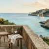Code : alt="Stone terrace overlooking a secluded French islands bay with a sailboat anchored in turquoise waters