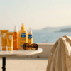 Selection of French pharmacy sunscreens including La Roche-Posay, Bioderma, and Avène on a table overlooking the Mediterranean sea