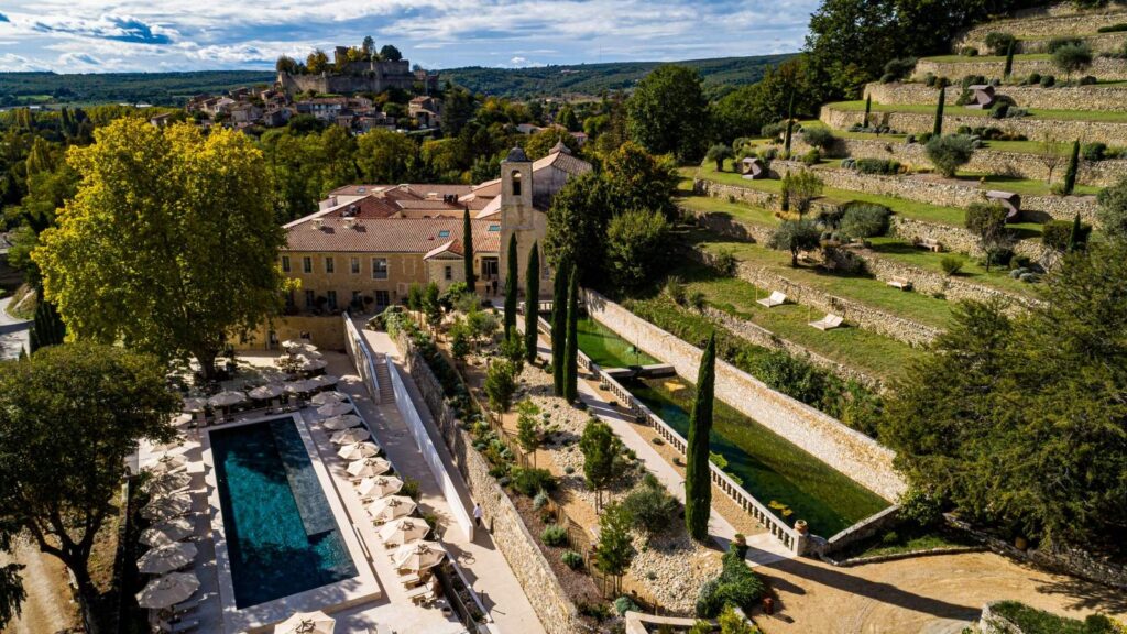 Aerial view of Couvent des Minimes Hotel & Spa showing the terraced gardens, outdoor pool, and the village of Mane