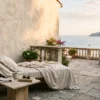 An elegant limestone terrace in Saint-Jean-Cap-Ferrat with cream linen drapes and a view of the Mediterranean sea